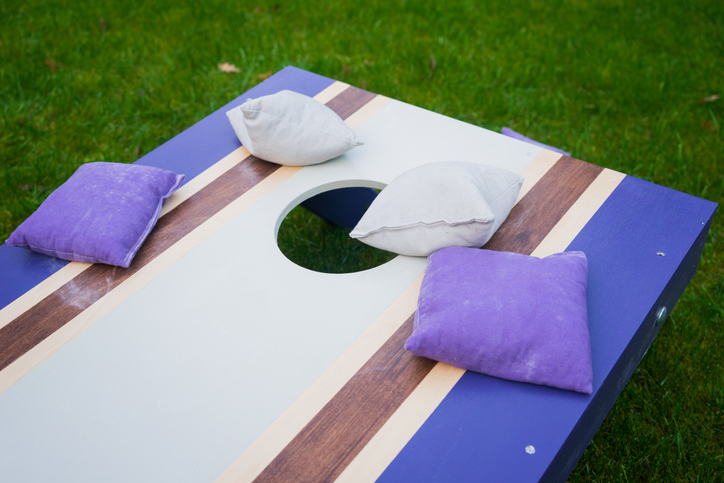 Close-up of blue and white bean bag toss game with purple beanbags